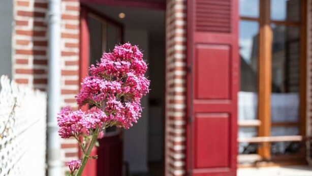 Un bâtiment avec des volets rouges et une façade en briques.