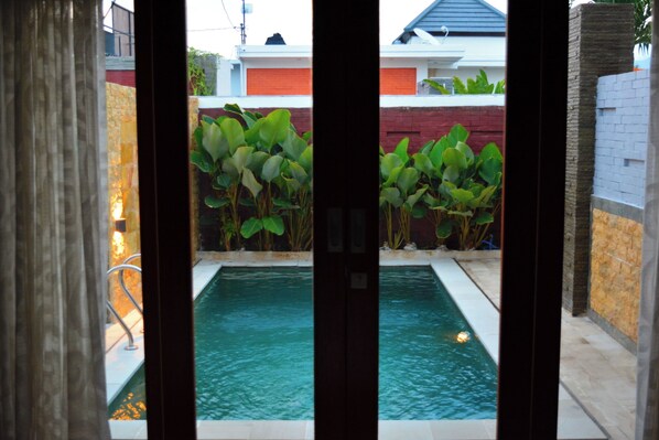 Relax by the serene pool surrounded by lush greenery.