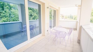 Enjoy al fresco dining on the balcony with a seating area featuring two sets of chairs and a table.