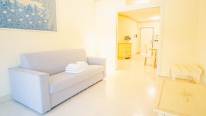 A modern living room with a grey sofa, a small table, and a painting on the wall. - 121 Relais du Lac Village - Italian Homing (Desenzano del Garda)
