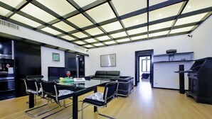 A modern kitchen with a glass-top dining table, black chairs, and a black sofa. - 4bnb - Spacious Porta Pia Apartment (Rome)