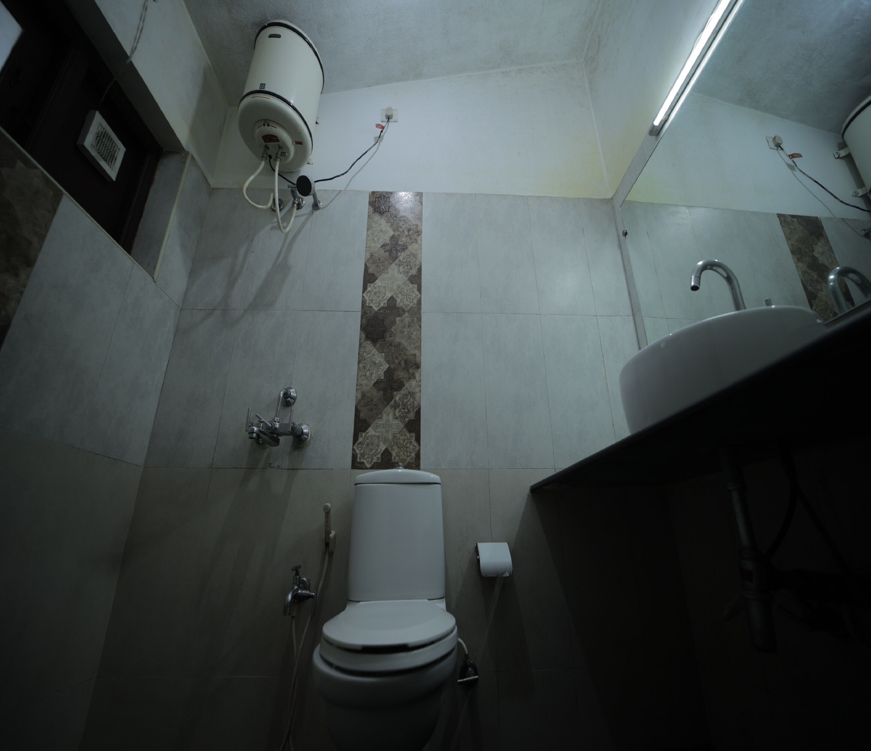 A bathroom with a toilet, a shower, and a sink.