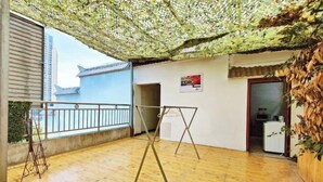 Een kamer met een balkon, een schommel en uitzicht op traditionele gebouwen.