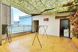 Una habitación con balcón, una hamaca y vistas a un edificio tradicional.