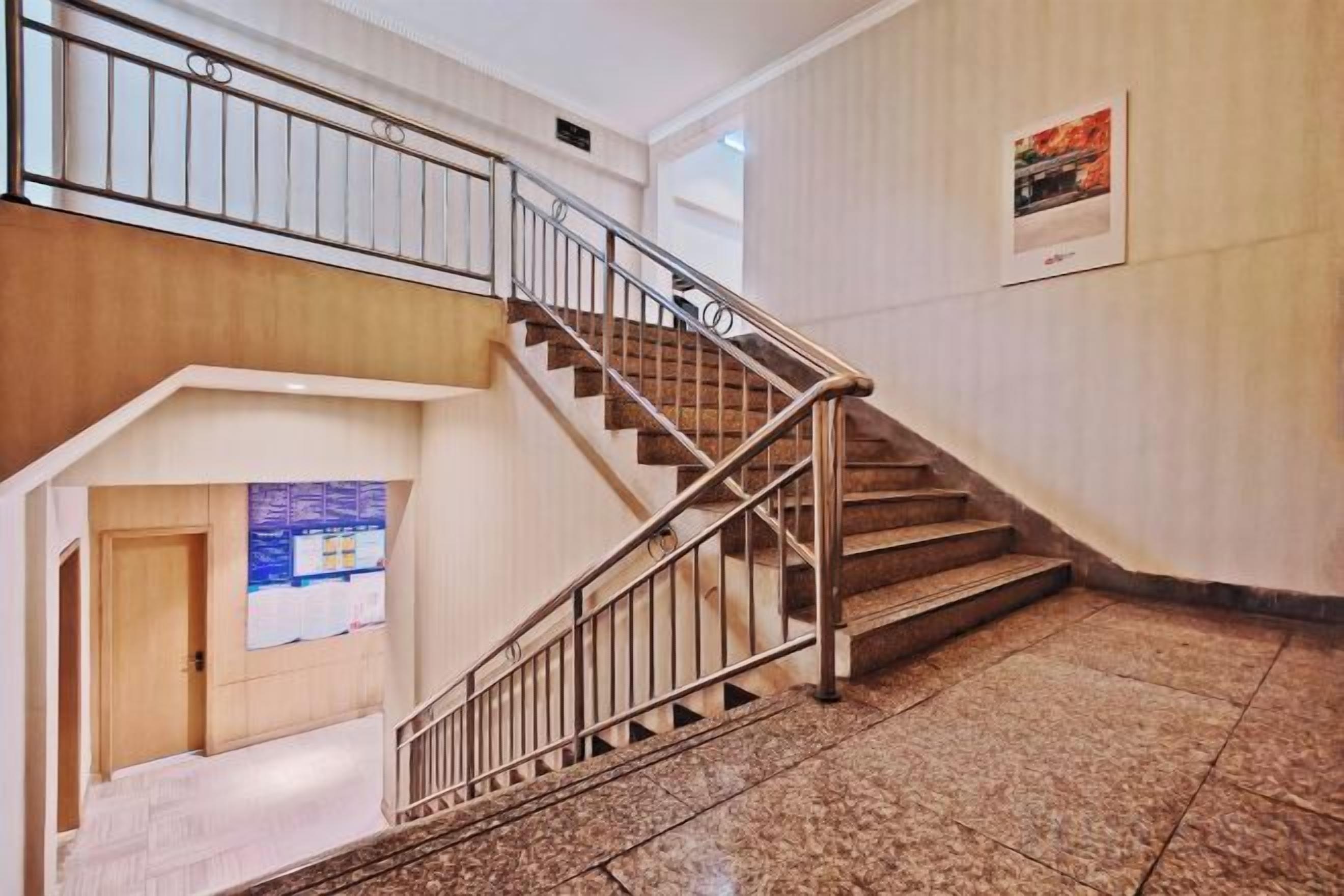 Una escalera con barandillas de metal que sube a un nivel superior.