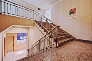 Una escalera con barandillas de metal que sube a un nivel superior.