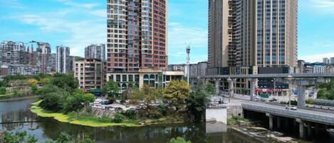 Un río con un puente, rodeado de vegetación y edificios altos.