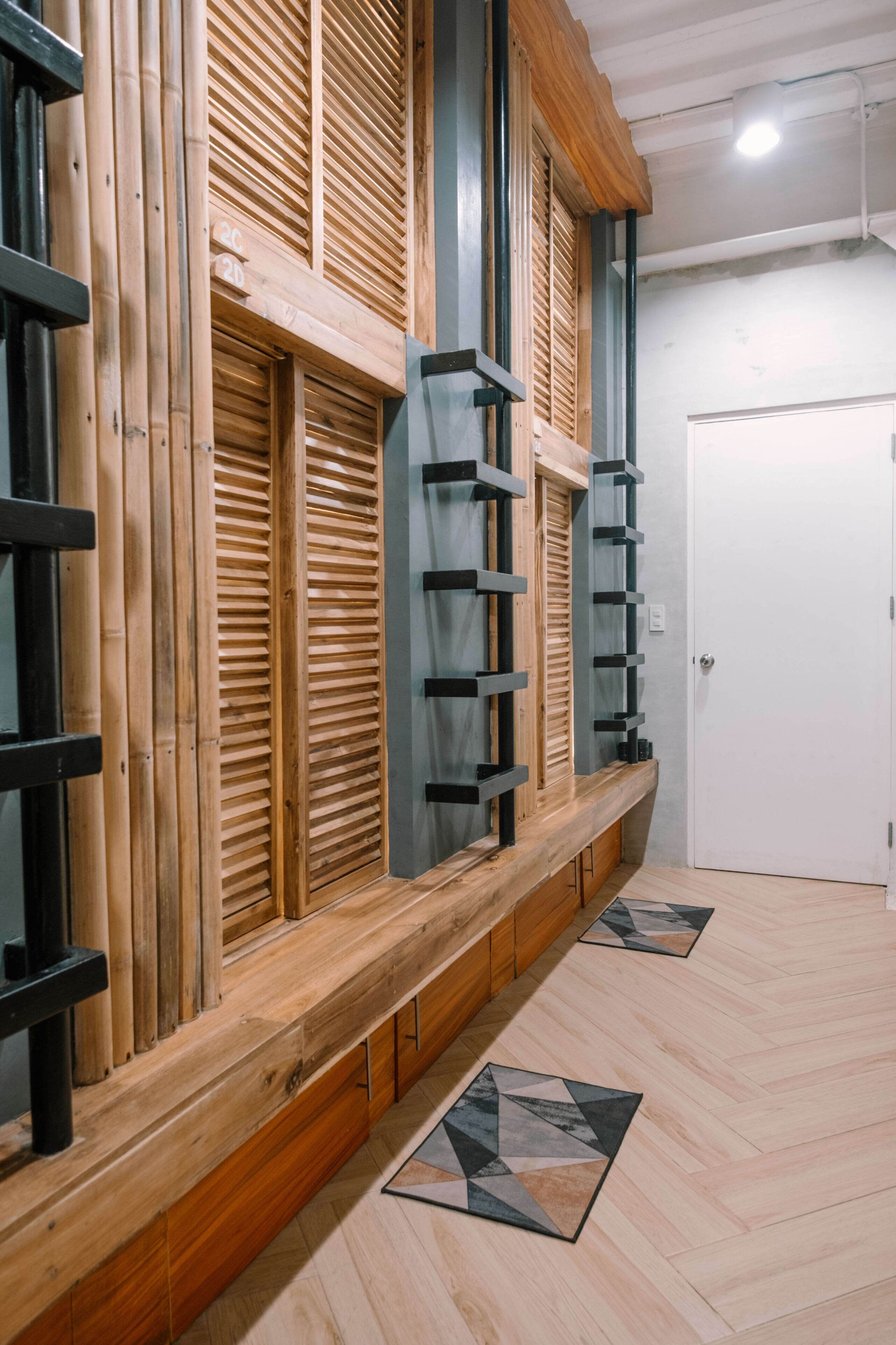 A room with a wooden bench, a white door, and a patterned floor.