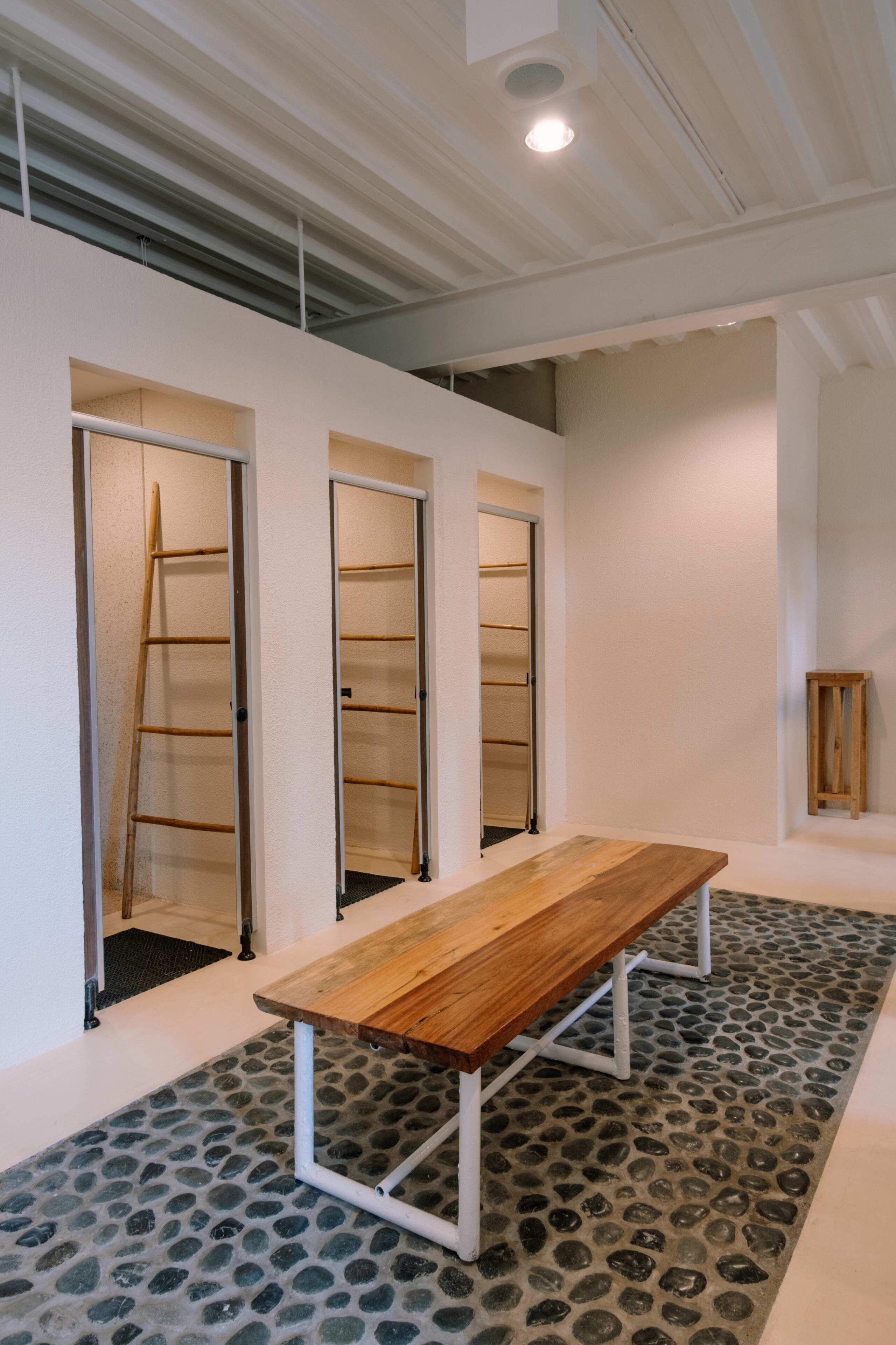 Un pasillo con un banco de madera, una escalera y una pequeña mesa.