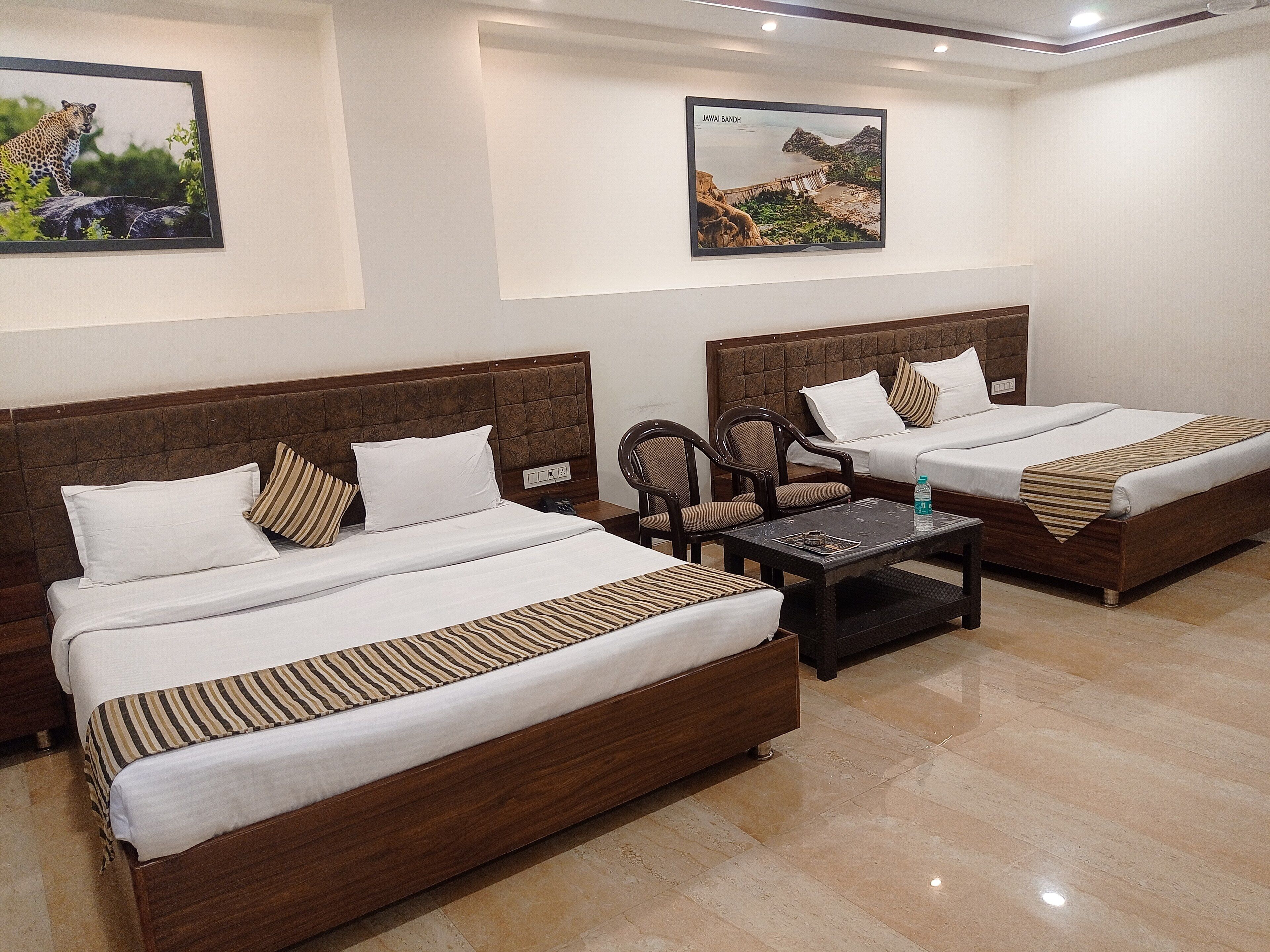 A hotel room with two beds, a small table, and two chairs.