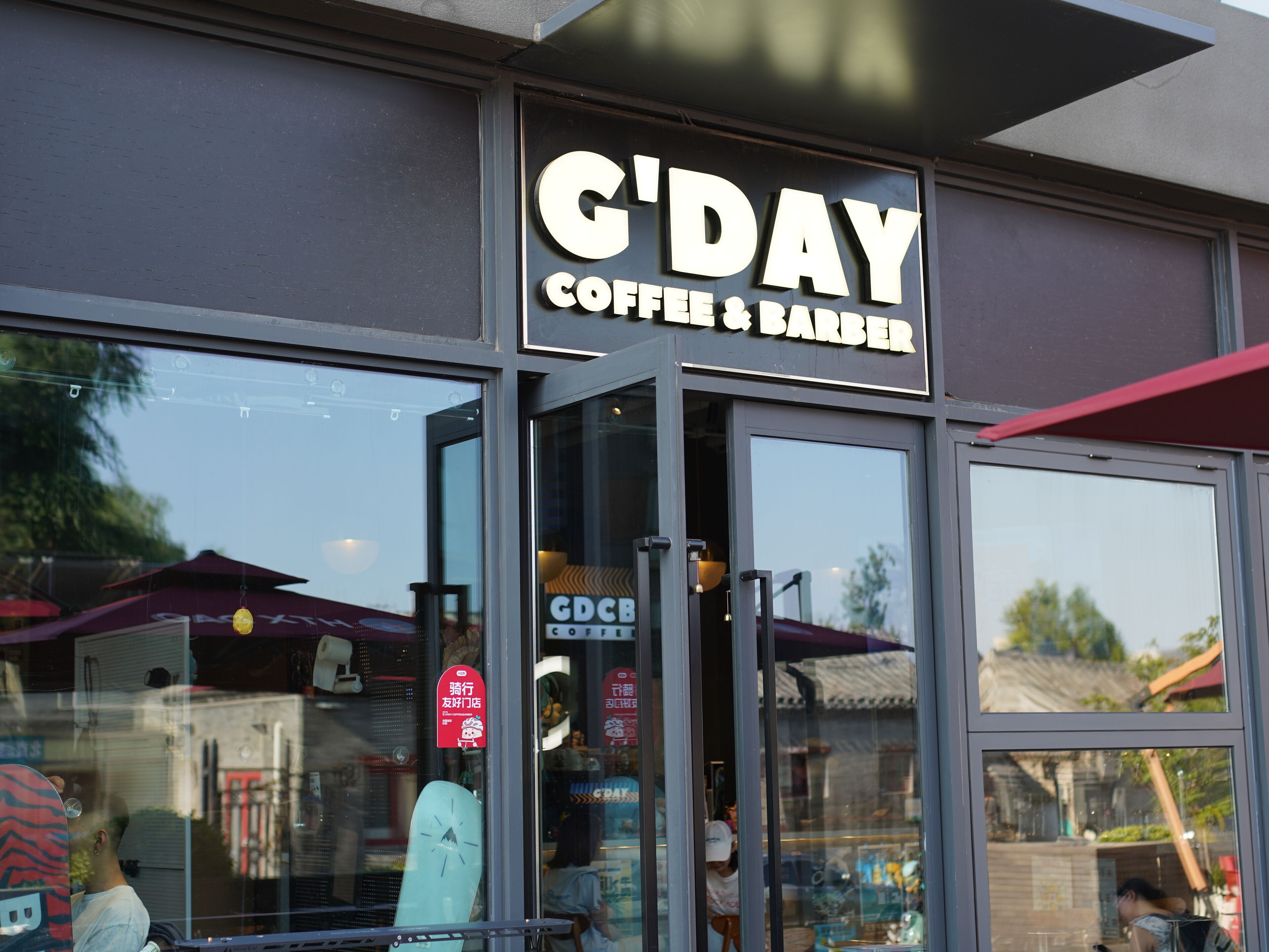 Una fachada con un letrero que dice "C'DAY COFFEE & BARBER".