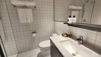 Een moderne badkamer met toilet, wastafel en douche.