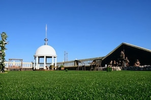 Une structure en forme de dôme blanc, un pavillon couvert et une zone herbeuse.