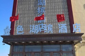 A hotel sign with Chinese characters and red flags. - Fangzheng Golden Lake Hotel (High-speed Railway Station) (Fangzheng)