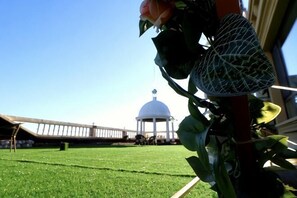 A view of a white dome structure, a grassy field, and a building with a red column. - Fangzheng Golden Lake Hotel (High-speed Railway Station) (Fangzheng)