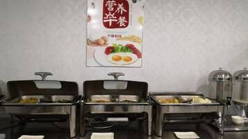 A buffet setup with multiple food dispensers and a poster on the wall.