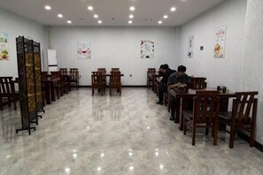 A restaurant with wooden tables and chairs, a polished marble floor, and posters on the walls. - Fangzheng Golden Lake Hotel (High-speed Railway Station) (Fangzheng)