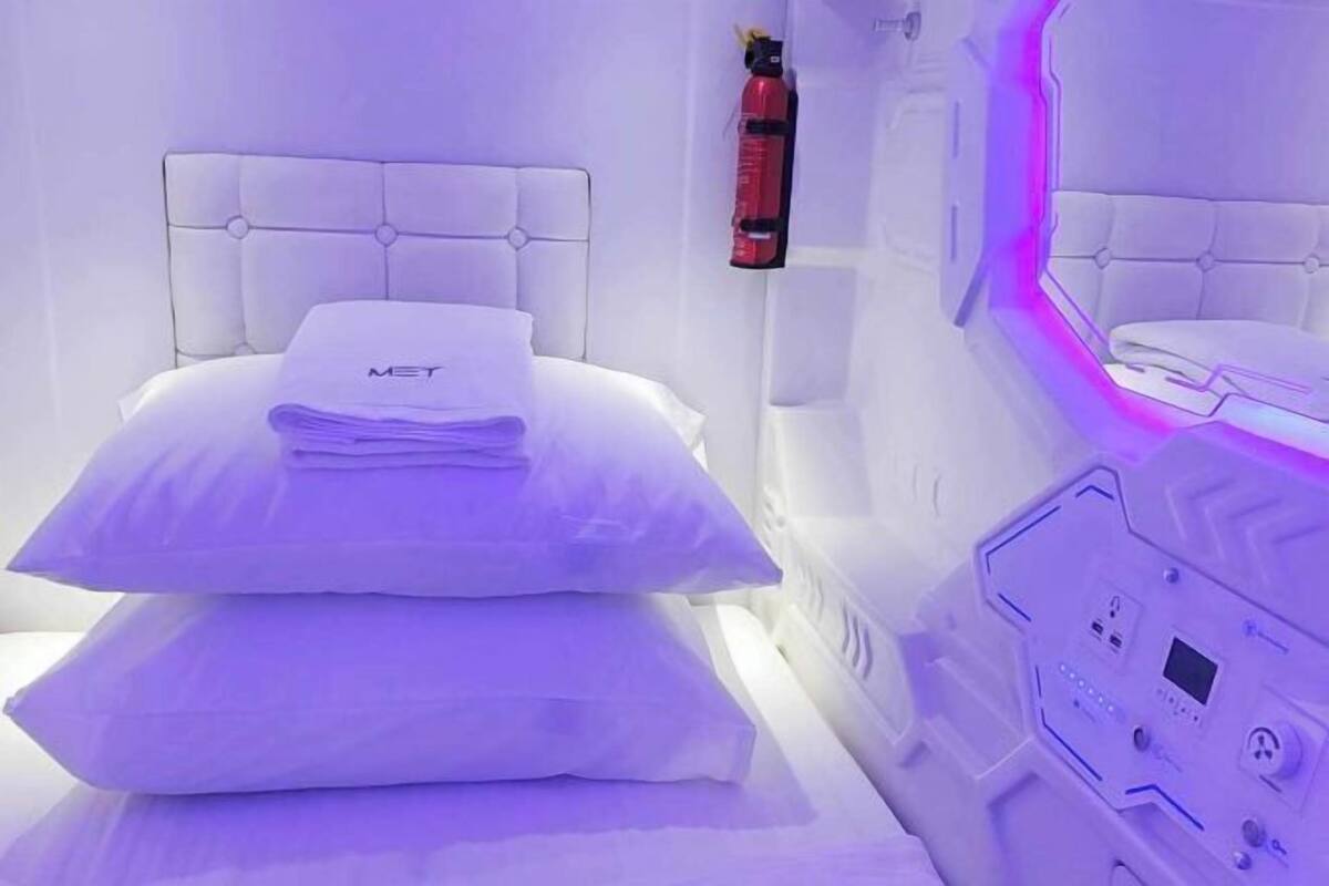 A room with a bed, a control panel, and a fire extinguisher.