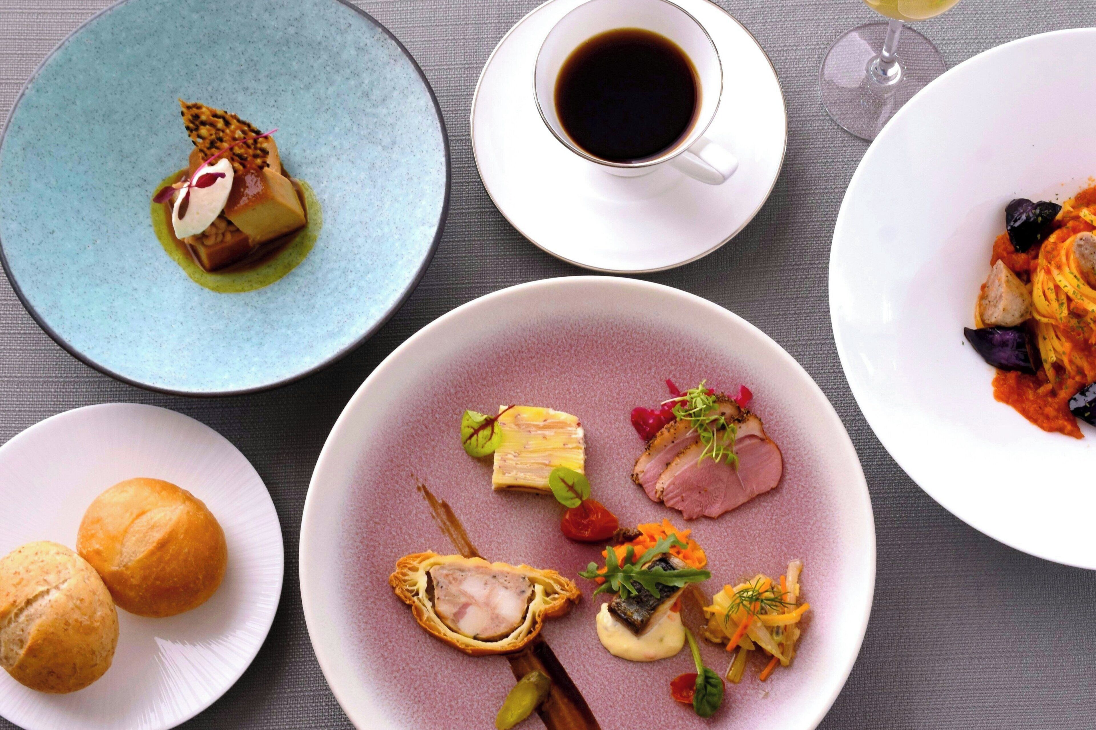 A table with various dishes and a cup of coffee.