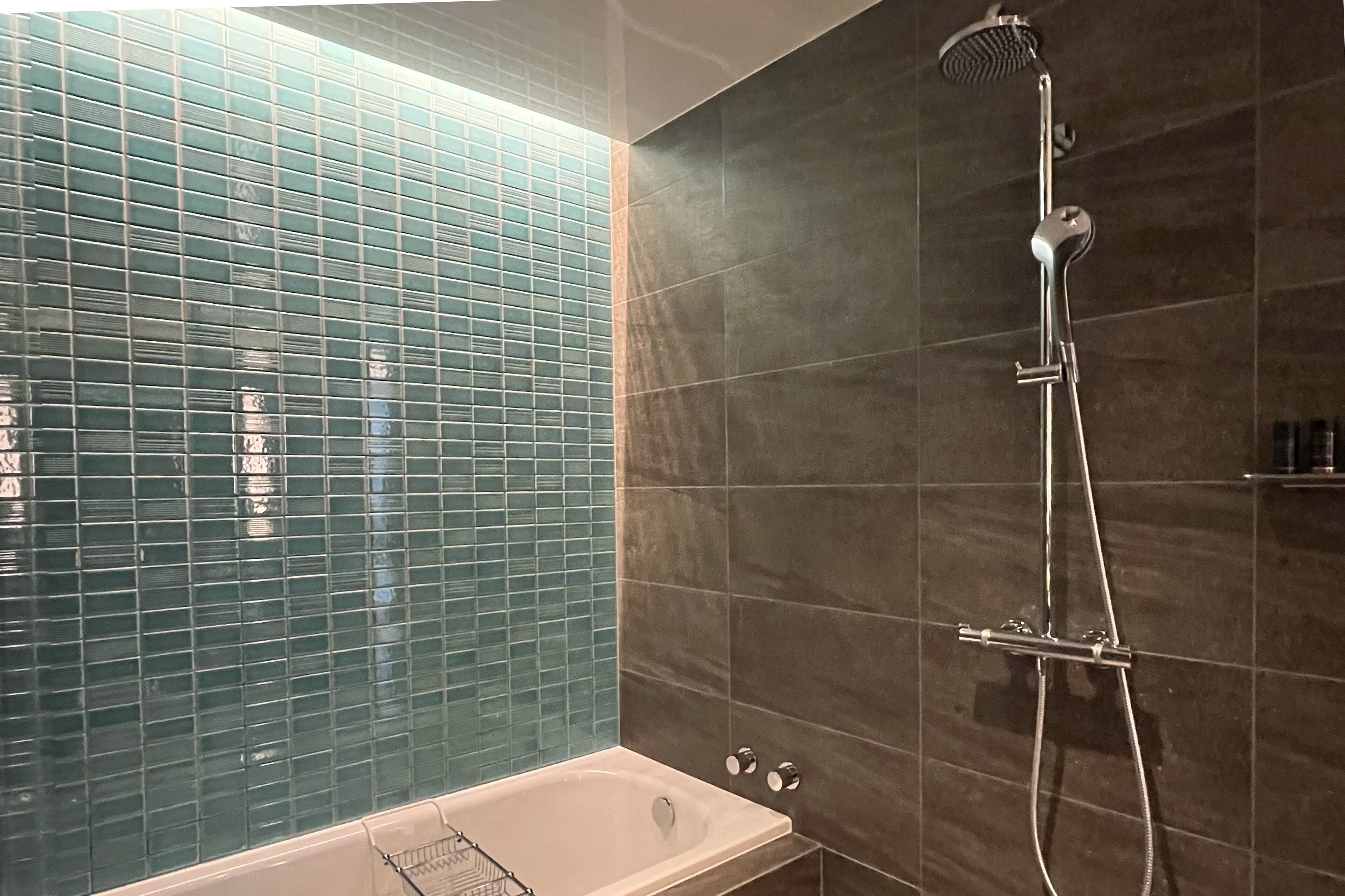 Ein Badezimmer mit einer Badewanne, einer Dusche und Fliesen.