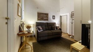 A cozy living room with a sofa, a coffee table, and a TV. - Minerva 5 - FromHometoRome (Roma)