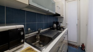 A compact kitchen with a gas stove, a built-in oven, and a stainless steel sink. - Minerva 5 - FromHometoRome (Roma)