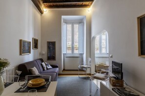 Een moderne woonkamer met een bank, een eettafel en een televisie.
