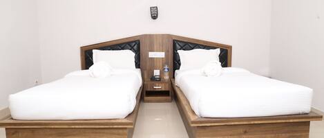 Una cama doble con cabecera de madera y ropa de cama blanca.