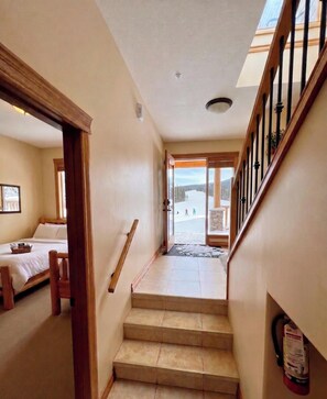 A staircase leading to a balcony with a view of a snowy landscape. - Sullivan Stone 3 True Ski-In/Ski-Out Mountain Home with Private Hot Tub! - Sleeps 10 (Kimberley)