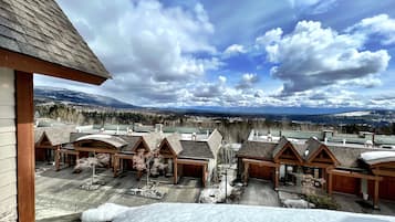 Une vue d’un complexe hôtelier comprenant plusieurs bâtiments de style chalet, un paysage enneigé et une chaîne de montagnes en arrière-plan.