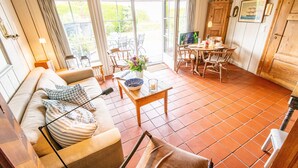 Een gezellige woonkamer met een bank, een eettafel en een televisie.