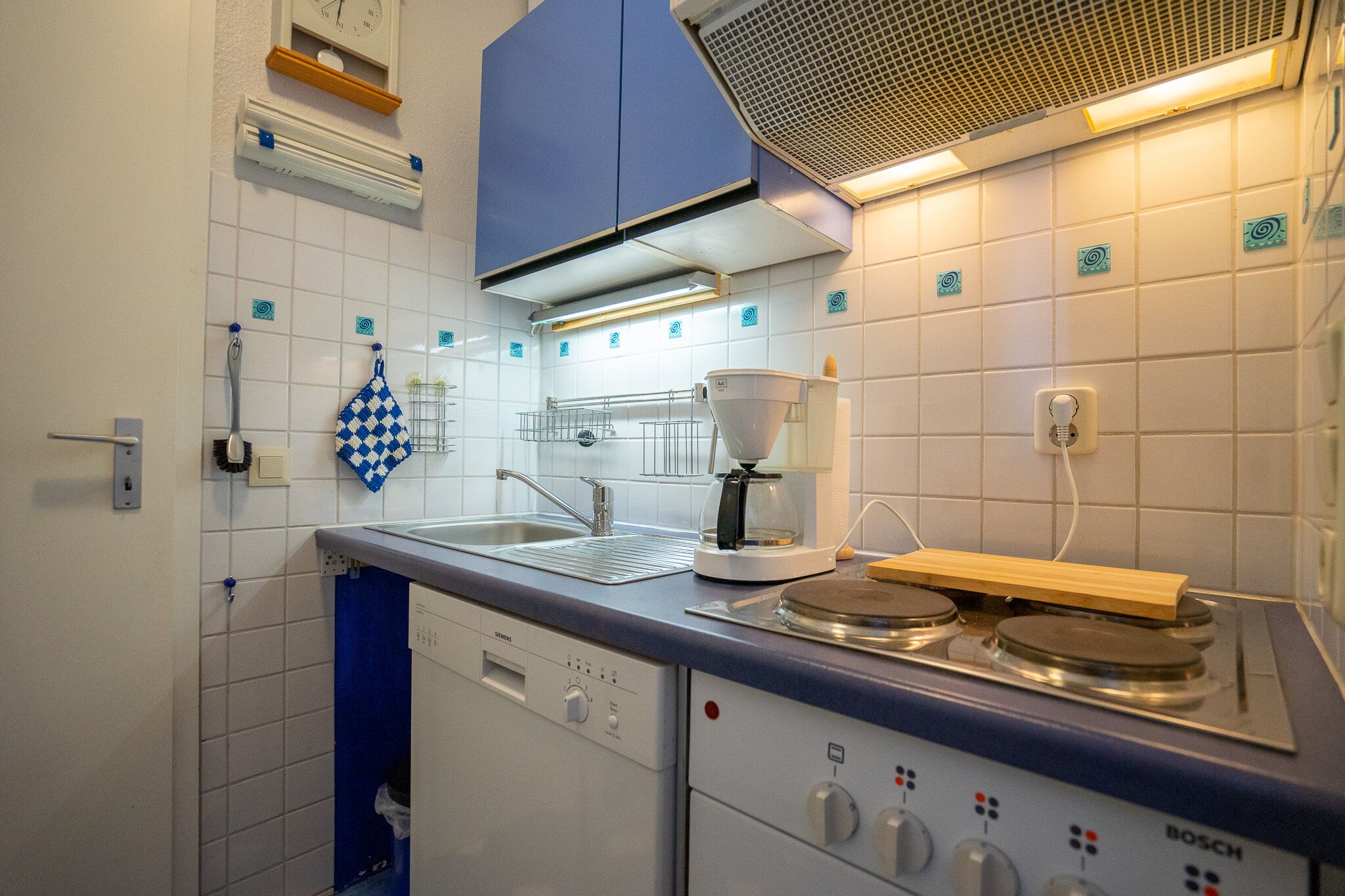 A kitchen with a Siemens dishwasher, Bosch stove, and a coffee maker.