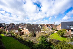 Ein Wohngebiet mit Häusern, grünen Rasenflächen und blauem Himmel.