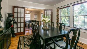 Un coin repas avec une table noire, des chaises assorties et un centre de table floral.
