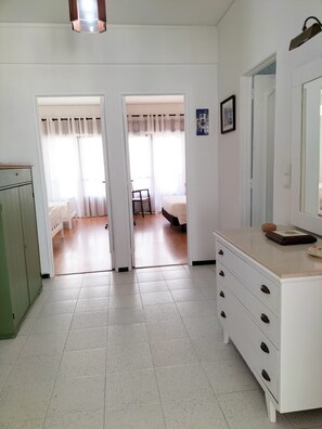 Ein Zimmer mit einem Bett, einem Schrank und einer Tür zu einem weiteren Raum.