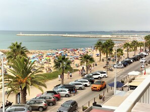 A beachside parking area with cars, palm trees, and a view of the beach and sea. - MAMAMIA II VISTA PRAIA (Quarteira)