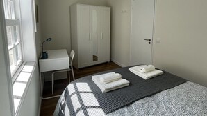 A bedroom with a bed, a desk, and a wardrobe. - Charming one-bedroom apartment in the heart of the city (Guimarães)