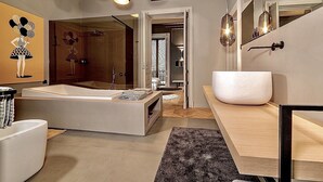 A modern bathroom with a large bathtub, a separate shower area, and a vanity with a large mirror. - Luxury apartment in the historic center (Catania)