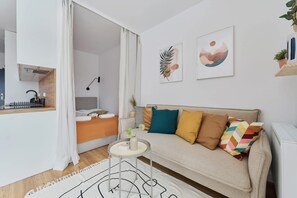 Ein modernes Wohnzimmer mit einer Couch, einem kleinen Tisch und Kunstwerken an der Wand.