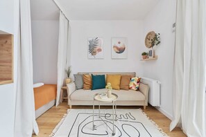 Une pièce confortable avec un canapé, une petite table et un radiateur.
