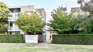 A modern residential building with a sign indicating 3-unit cottages. - Beige & Beautiful - Close to ANU (Turner)