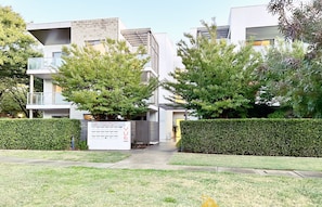 A modern residential building with a sign indicating 3-unit cottages. - Beige & Beautiful - Close to ANU (Turner)