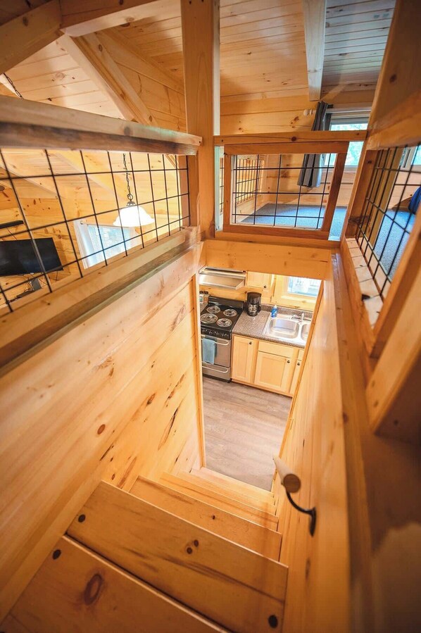 Un intérieur en bois comprenant un espace cuisine, avec un fourneau et des placards.