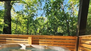 Ein Whirlpool mit Holzterrasse und Blick ins Waldgebiet.