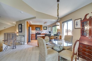 A spacious kitchen with modern appliances, a dining area with a glass table, and a cozy seating arrangement.