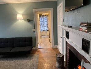 Cozy living space with a sofa, fireplace, and book collection.