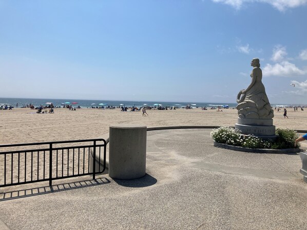 Stroll along the beachside promenade, taking in the views of the ocean and the iconic statue in the foreground.