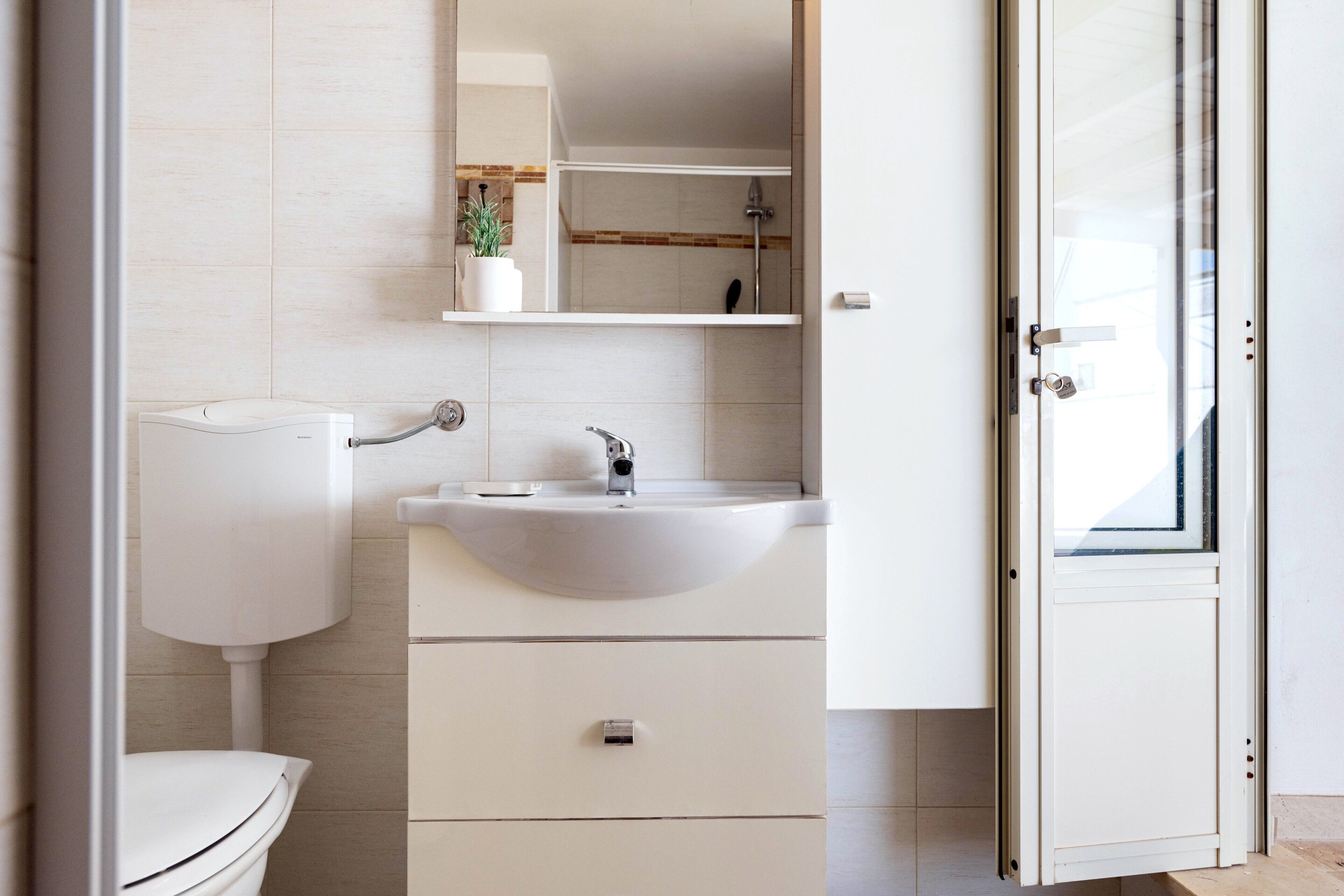 A modern bathroom with a toilet, sink, and cabinet.