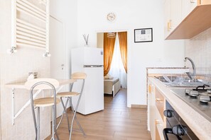 Ett modernt kök med en inbyggd ugn, en diskho och en matplats med ett bord och stolar.