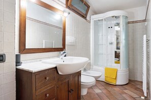 Ein Badezimmer mit Waschbecken, Spiegel, Schrank, Toilette und Dusche.